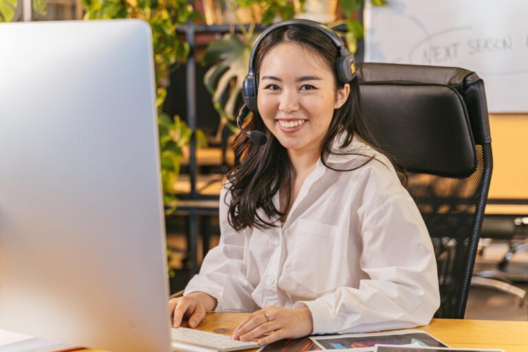 Businesswoman with headset working at her desk in an office environment.